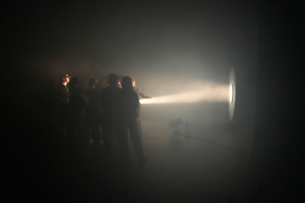 Foule devant un projecteur qui illumine une structure sur scène